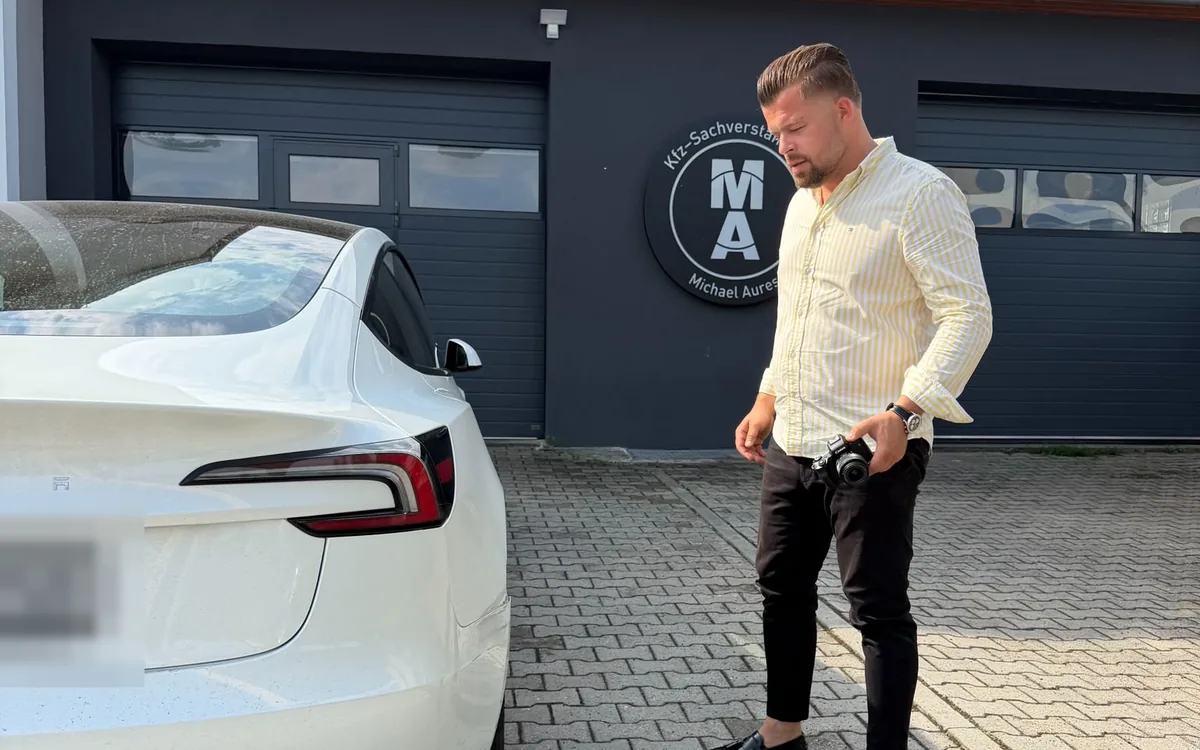 KFZ-Gutachter Michael Aures fotografiert den Schaden am Fahrzeugheck
