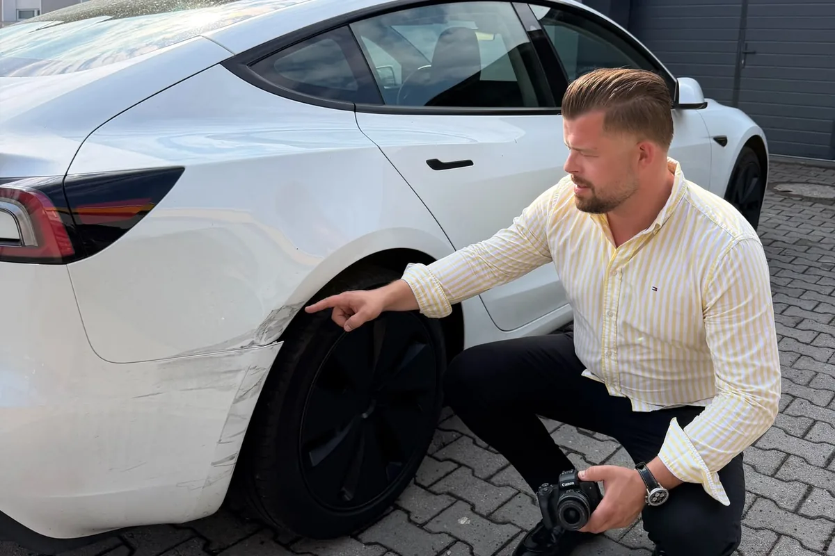 KFZ-Gutachter Michael Aures zeigt den Unfallschaden am Tesla Model 3